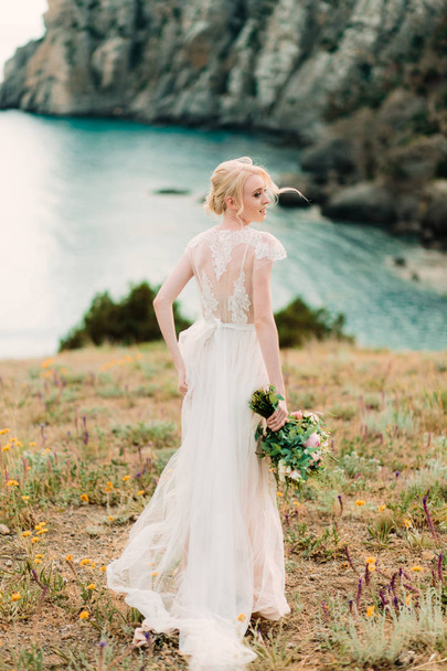 Prachtige bruid in mooie trouwjurk op natuurlijke achtergrond. - Foto, afbeelding