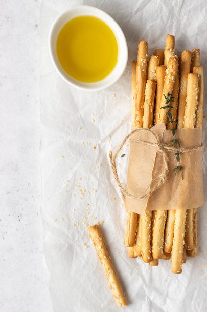 Italian grissini or salted bread sticks on a light stone background. Fresh italian snack. Copy space.  - Фото, изображение