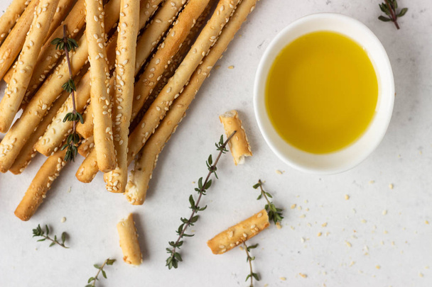 Italian grissini or salted bread sticks on a light stone background. Fresh italian snack. Copy space.  - Photo, Image