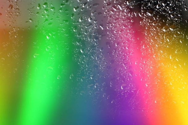 Abstrato borrado incrível colorido fundo arco-íris aurora boreal em vidro com gotas de chuva com luzes multicoloridas com espaço livre cópia para texto
 - Foto, Imagem