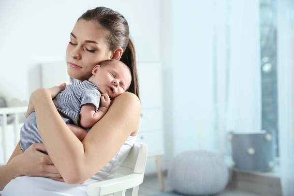 Young woman with her newborn baby at home. Space for text - Photo, Image