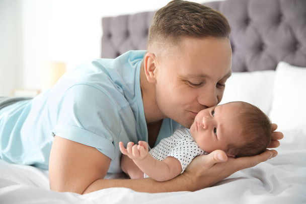 Man with his newborn baby on bed - Photo, image