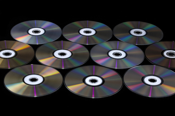 Компактные диски на черном фоне с цветовым отражением
 - Фото, изображение