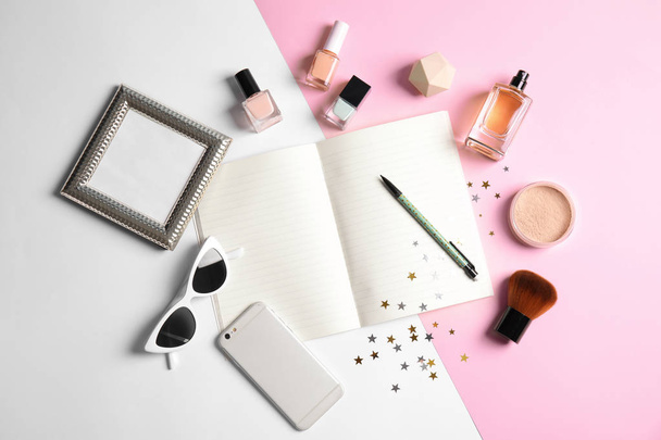 Flat lay composition with blank notebook, cosmetics and phone on color background, space for text. Blogger's workplace - Foto, Imagen