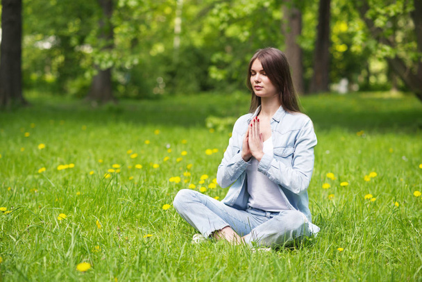Young girl meditating in park - Photo, Image