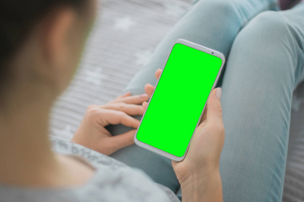 grüner Bildschirm mit Chroma-Ansicht von oben Handy-Attrappe Bild der Hände der Frau Schlüssel Smartphone - Foto, Bild