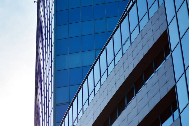 Nieuw kantoorgebouw in het zakencentrum. Muur van staal en glas met blauwe lucht.  - Foto, afbeelding