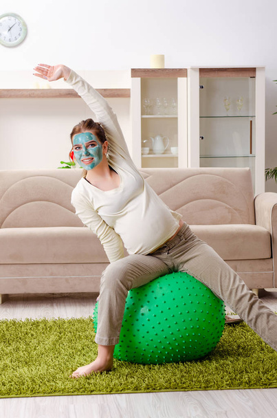 Jovem grávida fazendo exercícios em casa  - Foto, Imagem