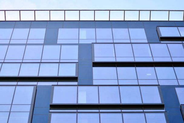 Nuevo edificio de oficinas en el centro de negocios. Pared de acero y vidrio con cielo azul.  - Foto, Imagen