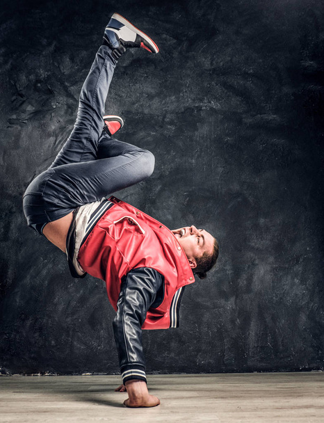 Emotional stylish dressed man performing break dance moves on the floor. - Foto, Bild