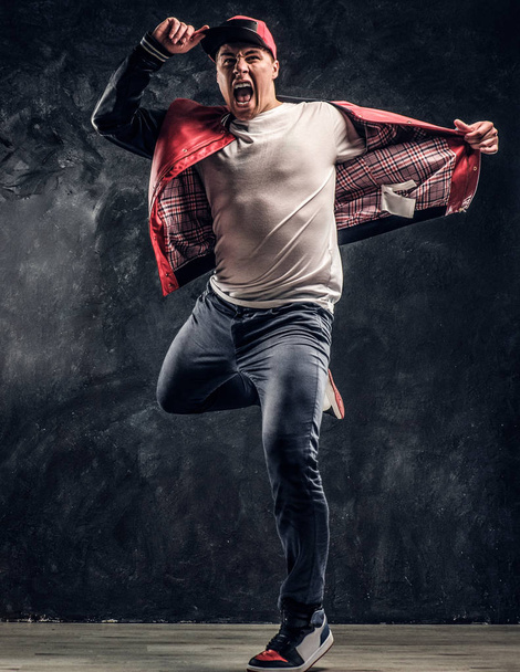 Stylowe facet wykonuje elementy akrobatyczne breakdance. - Zdjęcie, obraz