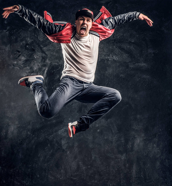 Elegante chico realiza breakdance acrobático elementos
. - Foto, Imagen