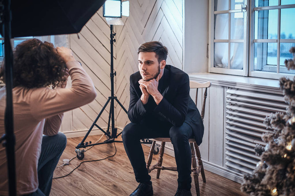 Photographe débutant lors d'une séance photo dans un studio avec un gars élégamment habillé
 - Photo, image