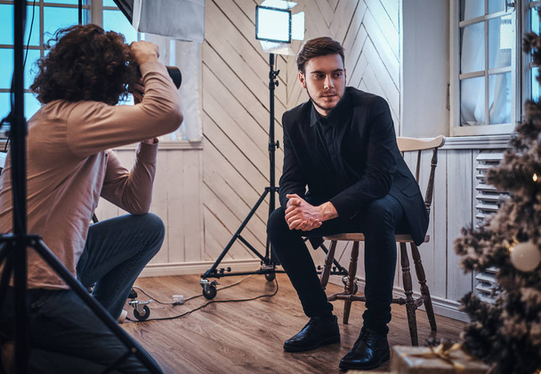 Photographe débutant lors d'une séance photo dans un studio avec un gars élégamment habillé
 - Photo, image