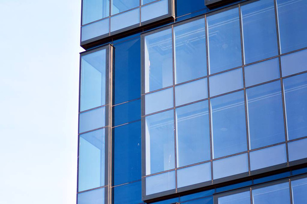 Új irodaház az üzleti központban. Acélból és üvegből készült fal kék égbolttal.  - Fotó, kép