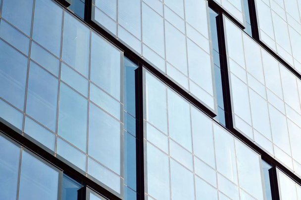 Neues Bürogebäude im Geschäftszentrum. Wand aus Stahl und Glas mit blauem Himmel.  - Foto, Bild