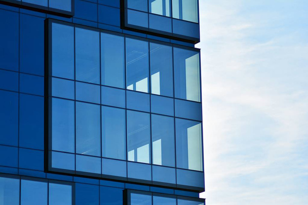 Új irodaház az üzleti központban. Acélból és üvegből készült fal kék égbolttal.  - Fotó, kép