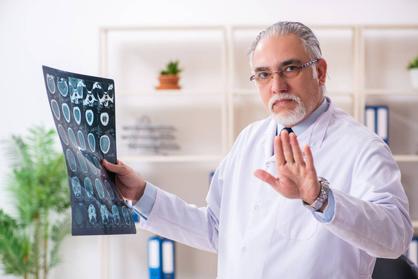 Aged male doctor radiologist in the clinic  - Foto, imagen