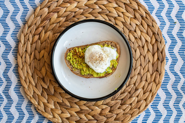 Avocado toast with poached eggs. served on a plate - Valokuva, kuva