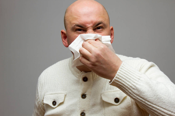 terveydenhuolto, flunssa, hygienia ja ihmiset käsite sairas vanhempi mies paperipyyhkeellä puhaltaa nenäänsä kotona
 - Valokuva, kuva