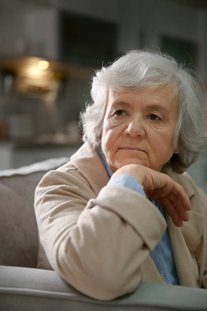 Portrait of elderly woman on sofa at home - Foto, Bild
