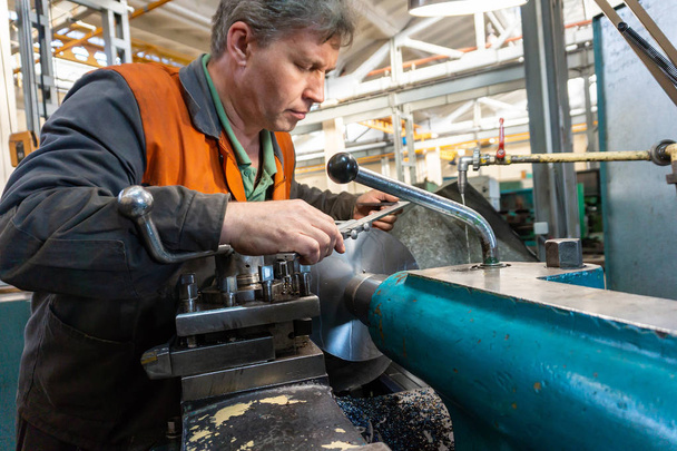Turner worker gère le processus de découpe mécanique des métaux sur un tour
. - Photo, image