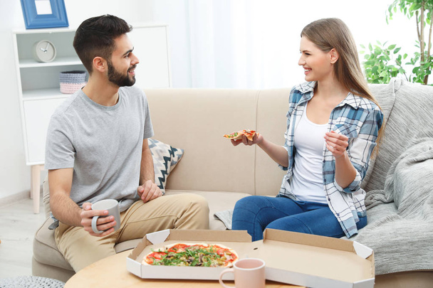 Young couple having pizza for lunch in living room. Food delivery - Valokuva, kuva