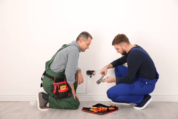 Electrician and apprentice working with wires indoors - Foto, Imagem