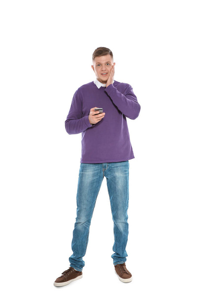 Handsome young man with phone on white background - Photo, image