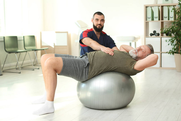 Physiotherapist working with patient in clinic. Rehabilitation therapy - Φωτογραφία, εικόνα