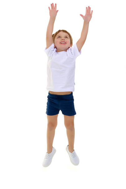 A little boy in a clean white T-shirt is jumping fun. - Photo, image