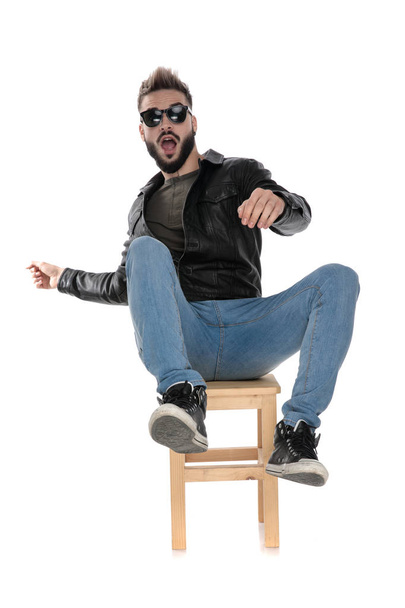 man in black jacket and blue jeans falling from chair - Photo, Image