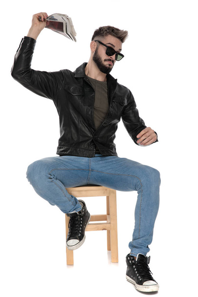 man sitting on chair and throwing newspaper - Foto, imagen