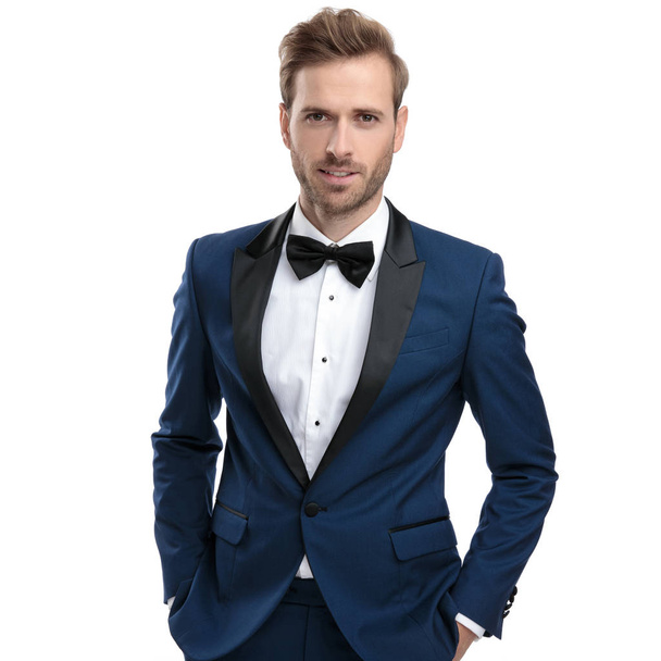 elegancki mężczyzna w niebieskim garniturze stojącego z rękami w kieszeniach - Zdjęcie, obraz