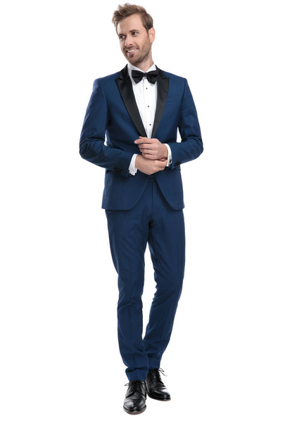 elegant guy in blue tuxedo adjusting his sleeve - Foto, Bild