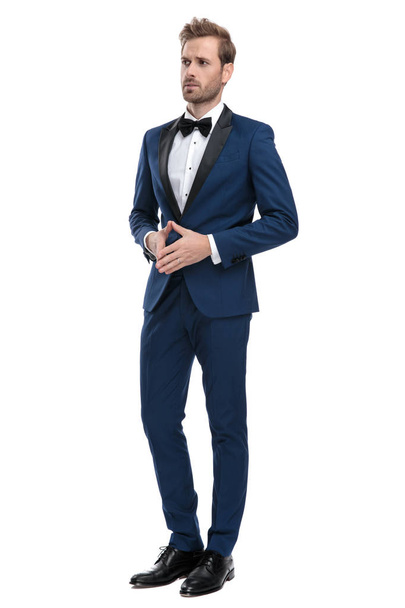 worried man in blue tuxedo standing with hands together - Photo, Image