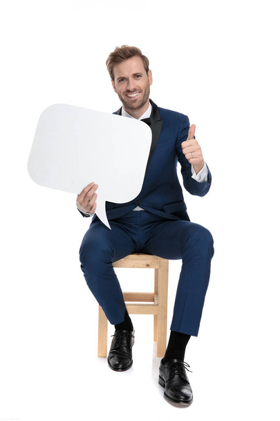 seated modern man showing ok gesture while holding talk bubble - Fotoğraf, Görsel