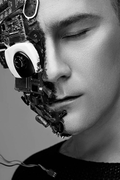 Yksivärinen studio kuva mies kyborgi, puoli kasvot tietokoneen elementtejä ja ammatillinen meikki, valkoinen irokeesi päähän. Tulevaisuuden teknologian käsite
 - Valokuva, kuva