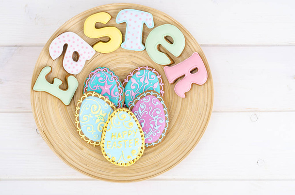 Homemade Easter pastry in shape of letters and eggs on wooden background. - Photo, image