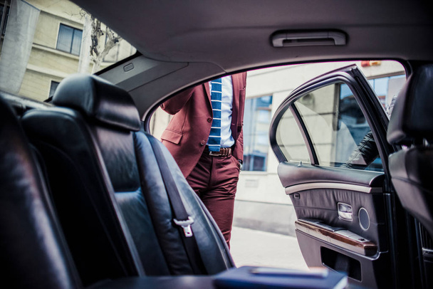Hombre de negocios rico conduciendo en una limusina y hablando por teléfono
 - Foto, imagen