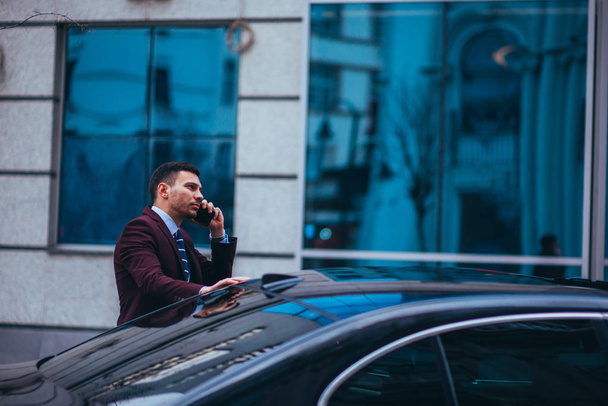 Предприниматель (бизнесмен), стоящий в городской местности и носящий
  - Фото, изображение