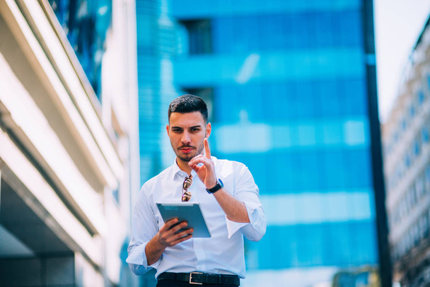 Business man holding his tablet and explaining his next plans an - Photo, Image