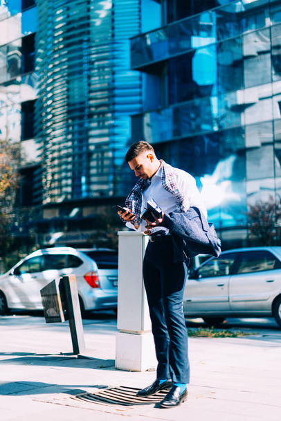 Giovane uomo d'affari sta camminando nel centro della città con il suo noteboo
 - Foto, immagini