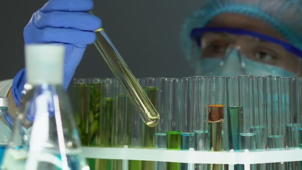 Chemiker nimmt Reagenzgläser mit Substanzen, überprüft kosmetologische Forschungsergebnisse - Filmmaterial, Video