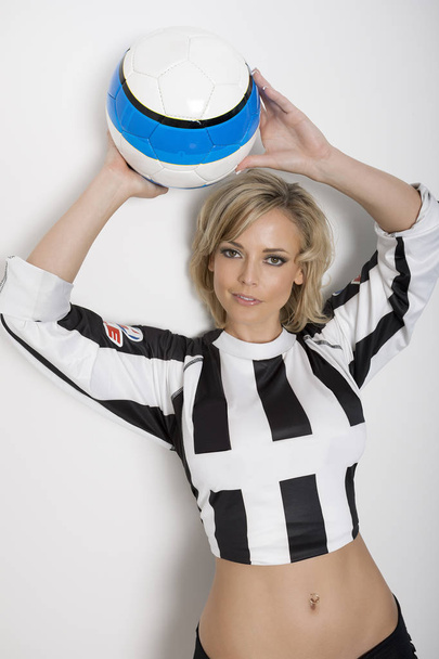 Pretty model holding a soccer ball over her head - Zdjęcie, obraz