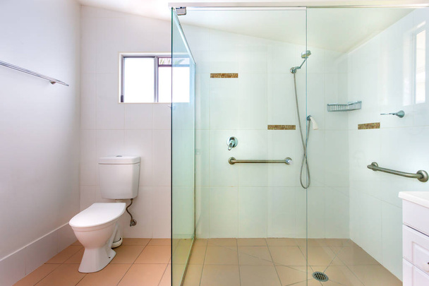 Salle de bain simple avec une grande douche
 - Photo, image