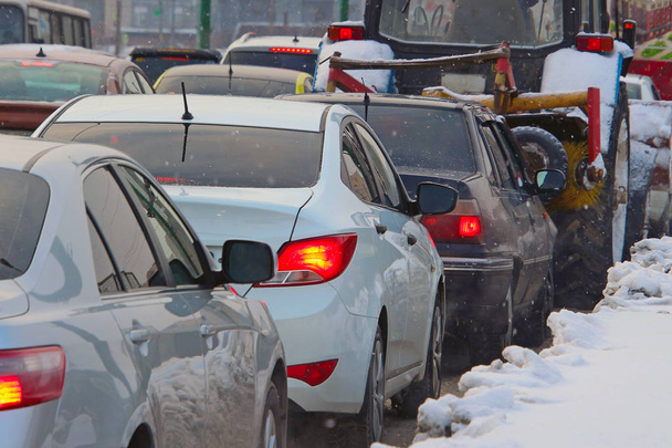 carros presos no trânsito em uma rua de inverno durante uma queda de neve
 - Foto, Imagem
