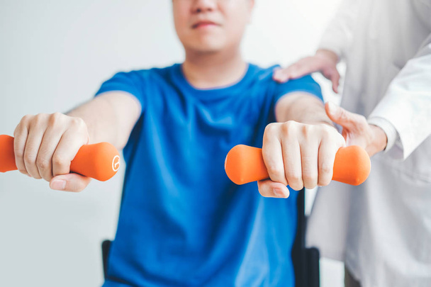 Physiotherapist man giving exercise with dumbbell treatment Abou - Foto, immagini