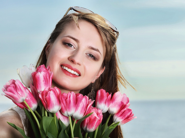 Smiling woman with bunch of flowers - Фото, зображення