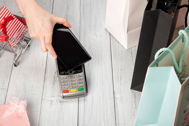 Kobieta płaci za pomocą technologii NFC na smartfonie  - Zdjęcie, obraz